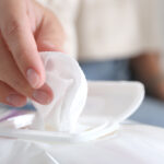 Woman,Taking,Wet,Wipe,Out,Of,Pack,Against,Blurred,Background,